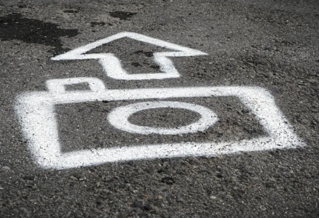 Camera icon with upward arrow spray painted on asphalt, learn photography with a deliberate pre-shot routine.